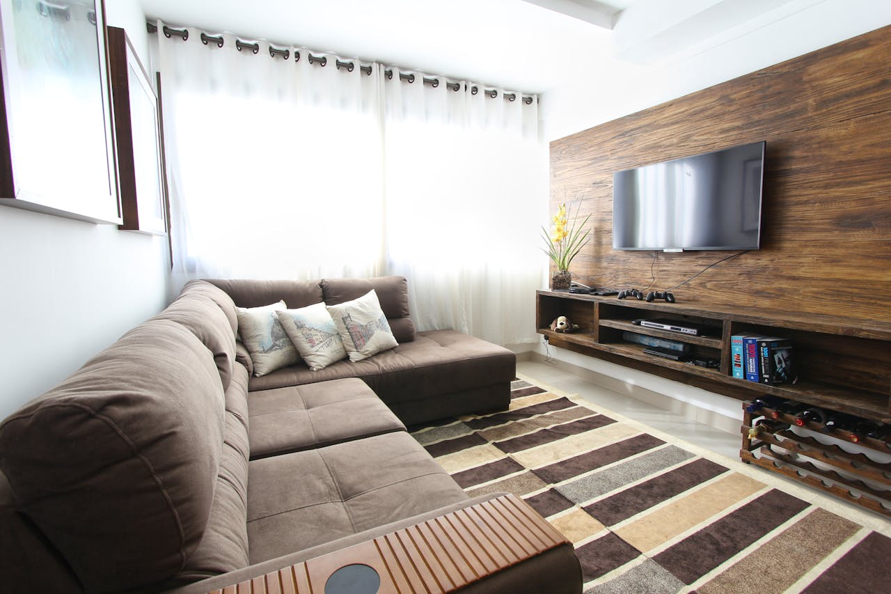 Stylish modern living room featuring a brown sofa, wall-mounted TV, and interior decor.